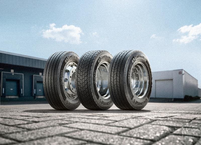 Conti Eco Ht 53 | ยางรถยนต์ ราคาอัปเดต 2026 ครบทุกยี่ห้อ รวมยาง Ev | Autotirechecking Three large tires standing upright on a paved lot beside an industrial building and loading dock.