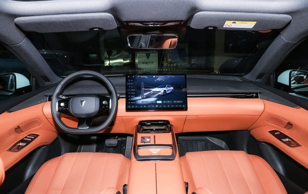 Deepal L072 | ยางรถยนต์ ราคาอัปเดต 2026 ครบทุกยี่ห้อ รวมยาง Ev | Autotirechecking Orange leather car interior with a large central touchscreen display and black steering wheel viewed from the back seat.