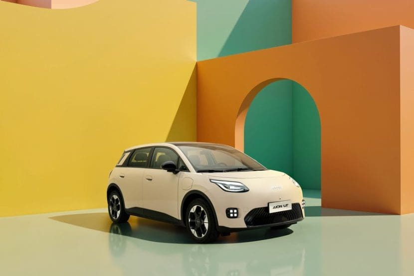 Img3056 | ยางรถยนต์ ราคาอัปเดต 2026 ครบทุกยี่ห้อ รวมยาง Ev | Autotirechecking White compact SUV parked in a vibrant geometric studio backdrop with yellow, orange, teal walls and an arched opening behind it.