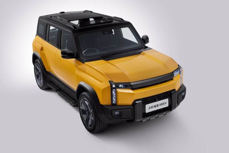 Three-quarter front-left view of a yellow SUV with a black roof and rugged bumper, set against a light gray background.
