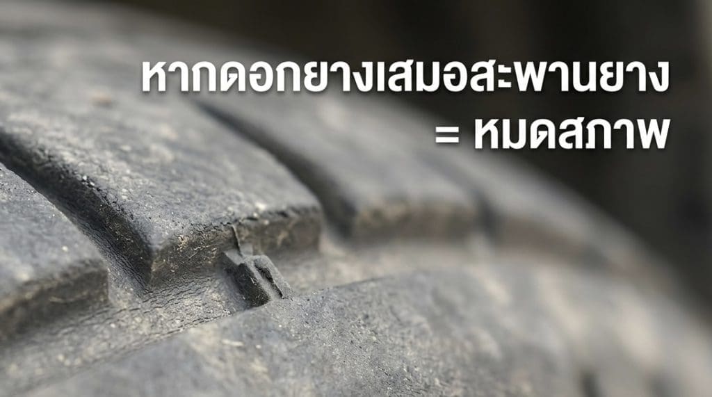 Img3096 | ยางรถยนต์ ราคาอัปเดต 2026 ครบทุกยี่ห้อ รวมยาง Ev | Autotirechecking Close-up of a dusty car tire tread with Thai warning text about worn tires indicating they’re unsafe or out of condition