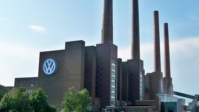 Img3240 | ยางรถยนต์ ราคาอัปเดต 2026 ครบทุกยี่ห้อ รวมยาง Ev | Autotirechecking Volkswagen factory with tall smokestacks and a large VW logo on the building