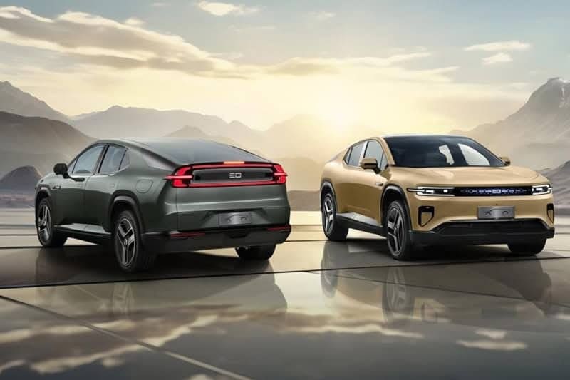 Img4451 | ยางรถยนต์ ราคาอัปเดต 2026 ครบทุกยี่ห้อ รวมยาง Ev | Autotirechecking Two modern SUVs on a reflective platform at sunset, one green-gray viewed from the rear and one gold viewed from the front.