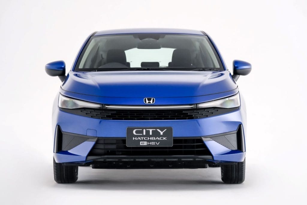 Img4843 | ยางรถยนต์ ราคาอัปเดต 2026 ครบทุกยี่ห้อ รวมยาง Ev | Autotirechecking Front view of a blue Honda City Hatchback in a studio setting, showing grille, headlights, and bumper against a white background.