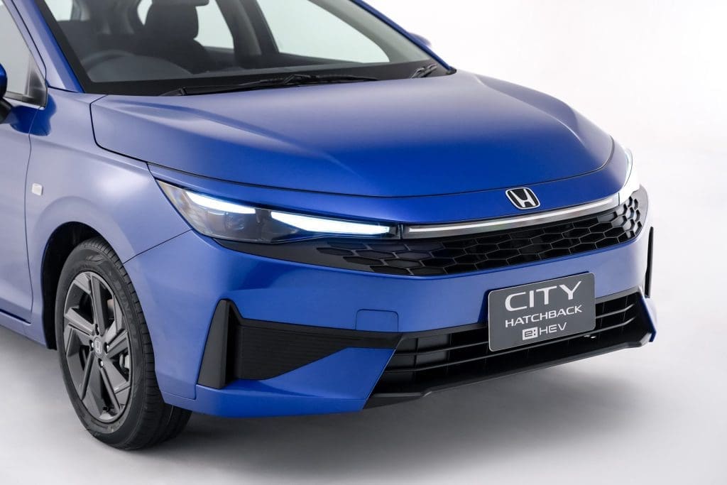 Img4844 | ยางรถยนต์ ราคาอัปเดต 2026 ครบทุกยี่ห้อ รวมยาง Ev | Autotirechecking Front-left view of a blue Honda City Hatchback BEV, featuring slim LED headlights and a bold black grille with a BEV badge on the plate area.