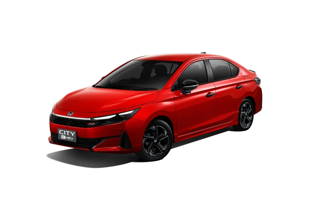 Img4845 | ยางรถยนต์ ราคาอัปเดต 2026 ครบทุกยี่ห้อ รวมยาง Ev | Autotirechecking Front three-quarter view of a red Honda City RS e:HEV sedan with black grille and alloy wheels, shown from the passenger side corner, against a white background.