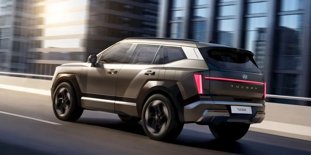 Img4867 | ยางรถยนต์ ราคาอัปเดต 2026 ครบทุกยี่ห้อ รวมยาง Ev | Autotirechecking Hyundai Tucson SUV driving on an urban highway with glass buildings in the background, in motion at speed.