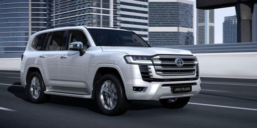 Img4886 | ยางรถยนต์ ราคาอัปเดต 2026 ครบทุกยี่ห้อ รวมยาง Ev | Autotirechecking Silver Toyota Land Cruiser SUV driving on an elevated city highway with skyscrapers in the background.