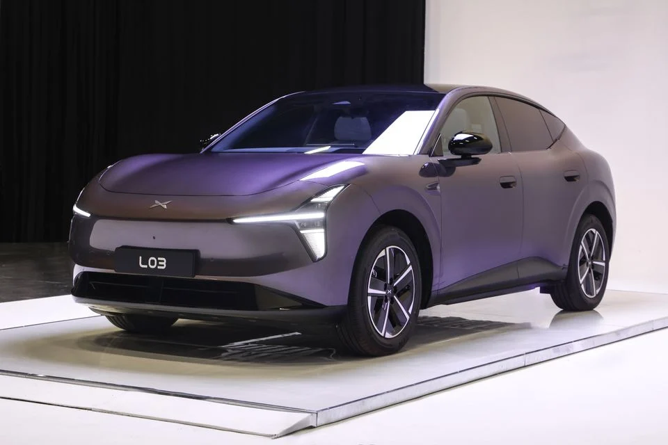 Img4924 | ยางรถยนต์ ราคาอัปเดต 2026 ครบทุกยี่ห้อ รวมยาง Ev | Autotirechecking Front three-quarter view of a glossy purple electric SUV on a white exhibition platform with slim LED headlights.