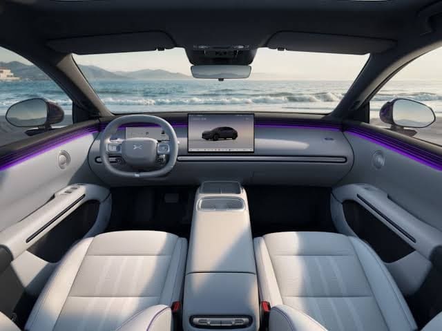 Img4929 | ยางรถยนต์ ราคาอัปเดต 2026 ครบทุกยี่ห้อ รวมยาง Ev | Autotirechecking Luxurious car interior with white leather seats, large touchscreen, purple ambient lighting, and an ocean view outside from the windshield.