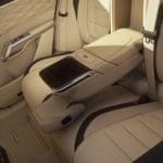 Img5144 | ยางรถยนต์ ราคาอัปเดต 2026 ครบทุกยี่ห้อ รวมยาง Ev | Autotirechecking Rear seating area of a beige luxury car with a fold-down center armrest and storage compartment