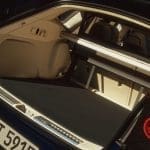 Img5145 | ยางรถยนต์ ราคาอัปเดต 2026 ครบทุกยี่ห้อ รวมยาง Ev | Autotirechecking Open trunk of a blue car showing a flat cargo area with rear seats folded and a metal loading rail; German license plate visible on left side.