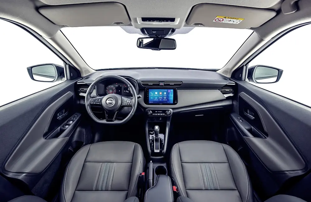 Kick20263 | ยางรถยนต์ ราคาอัปเดต 2026 ครบทุกยี่ห้อ รวมยาง Ev | Autotirechecking Front interior of a Nissan sedan showing steering wheel, center touchscreen, and leather seats in a dark cabin