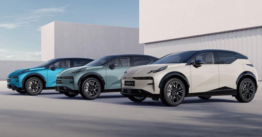 Three modern electric SUVs parked side by side in blue, teal, and beige against a light, minimalist backdrop.